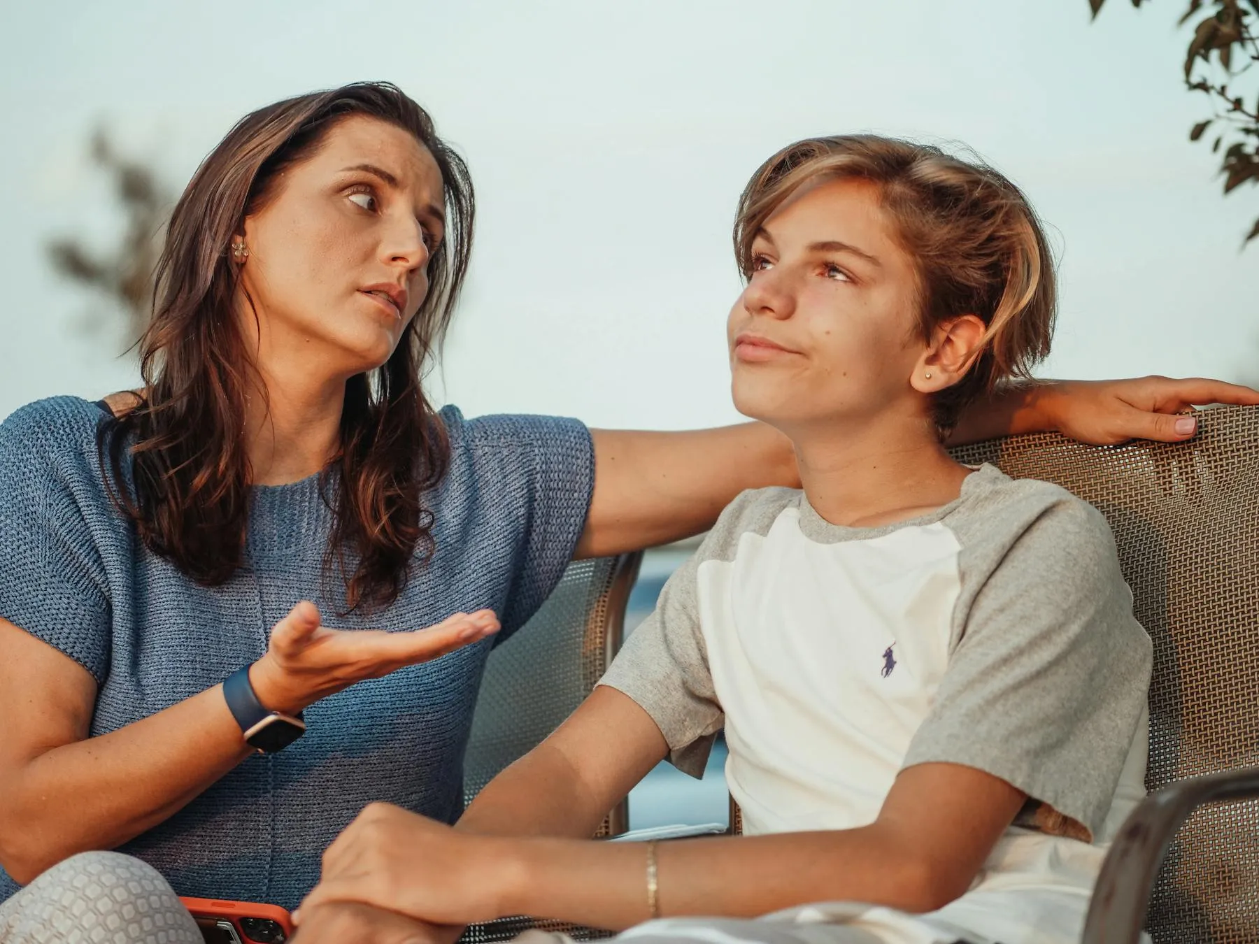 Mother and her teenage athlete talking through something together outdoors