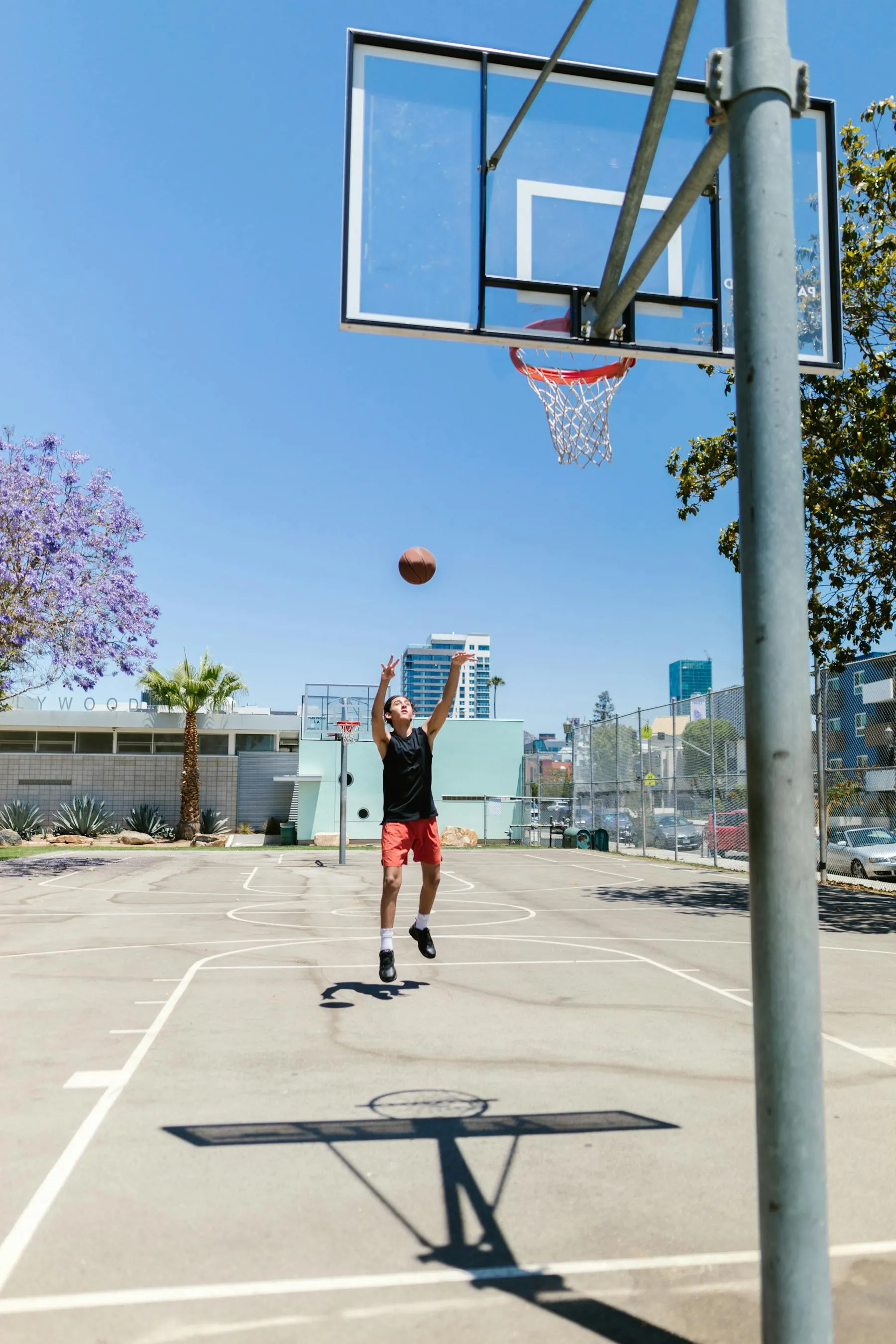 Young basketball player going up for a shot on an outdoor Los Angeles court
