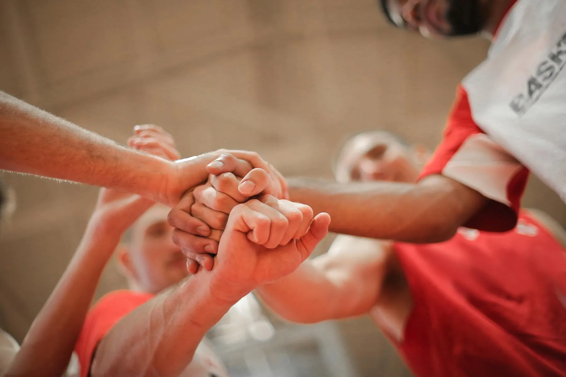 Basketball teammates stacking their fists together in a huddle